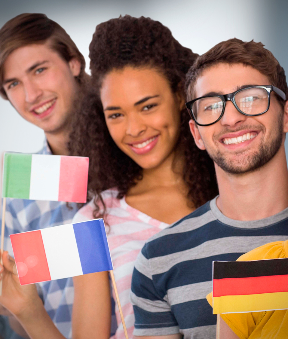 Cinco estudiantes sonrientes sujetando cada uno una bandera de un país: Alemania, Francia, Italia, Estados Unidos y Portugal