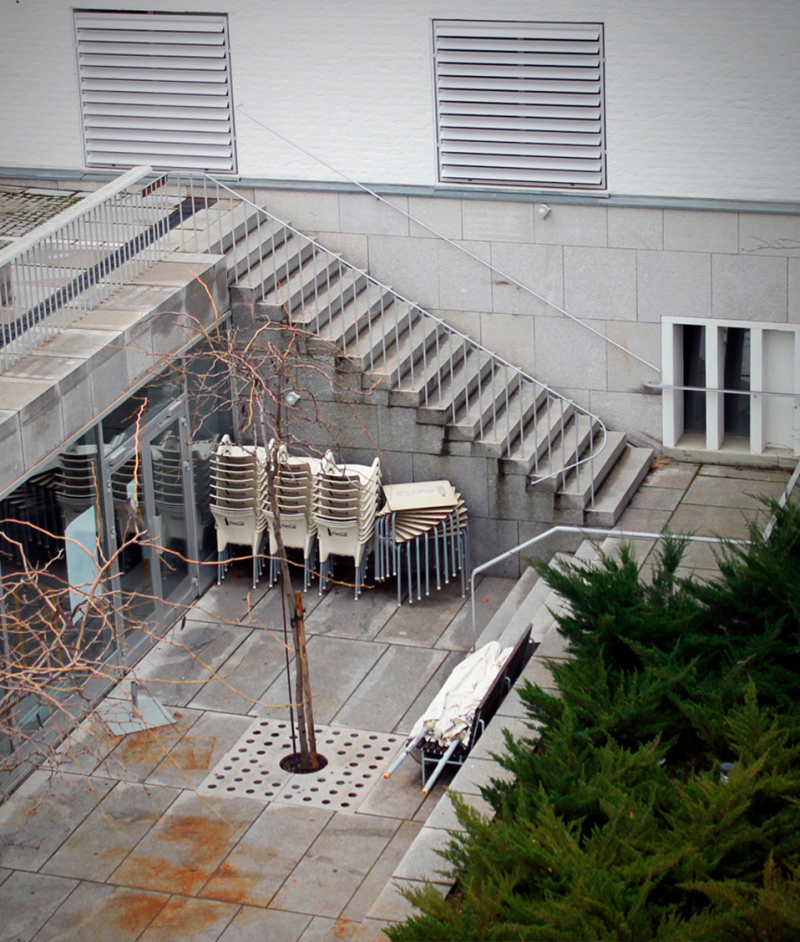 Imagen de una terraza en la que se ven varias sillas y mesas apiladas