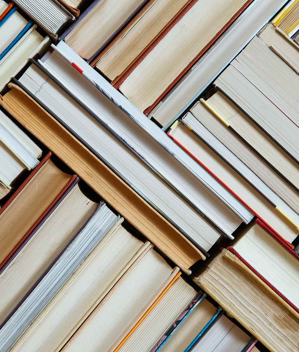 Imagen en la que se muestran varios libros apilados de perfil.