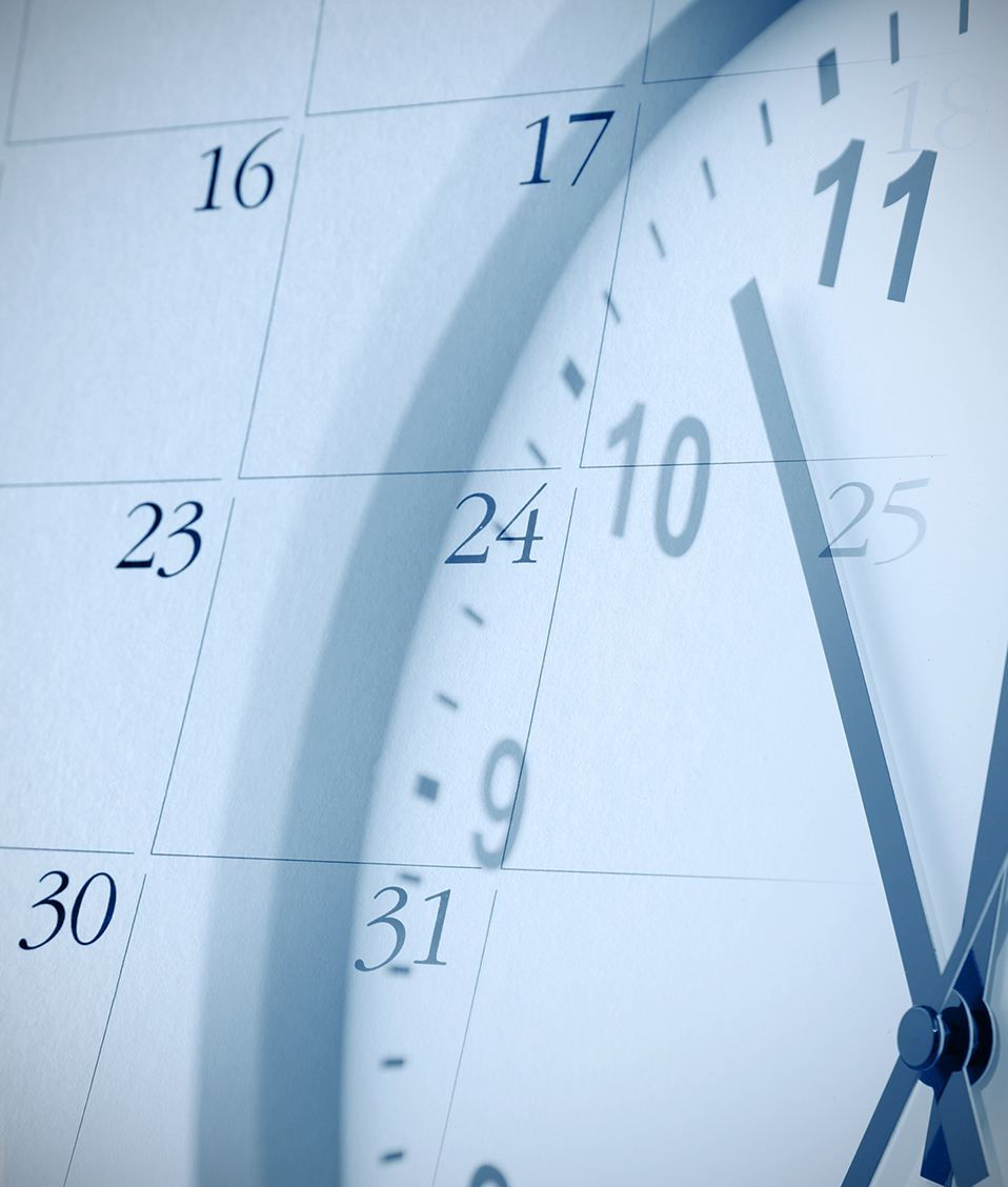 Imagen de un reloj superpuesto a la hoja de calendario de un mes