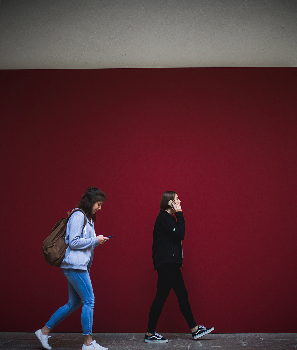 Dos estudientes caminando por uno de los patios del Hospital Real entre dos columnas