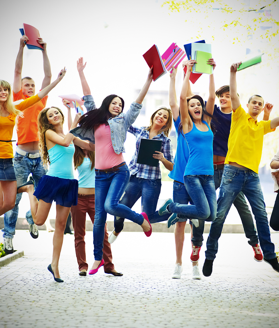 Estudiantes saltando felices con libretas en la mano 